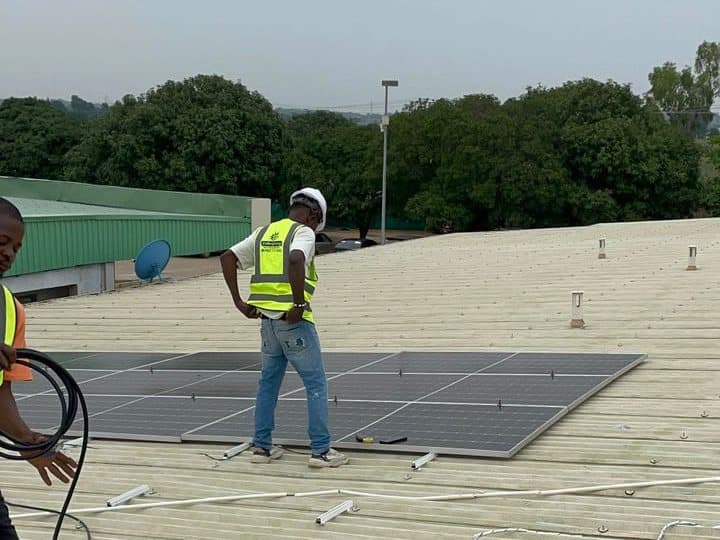 Engineers laying panels across a long metal factory roof