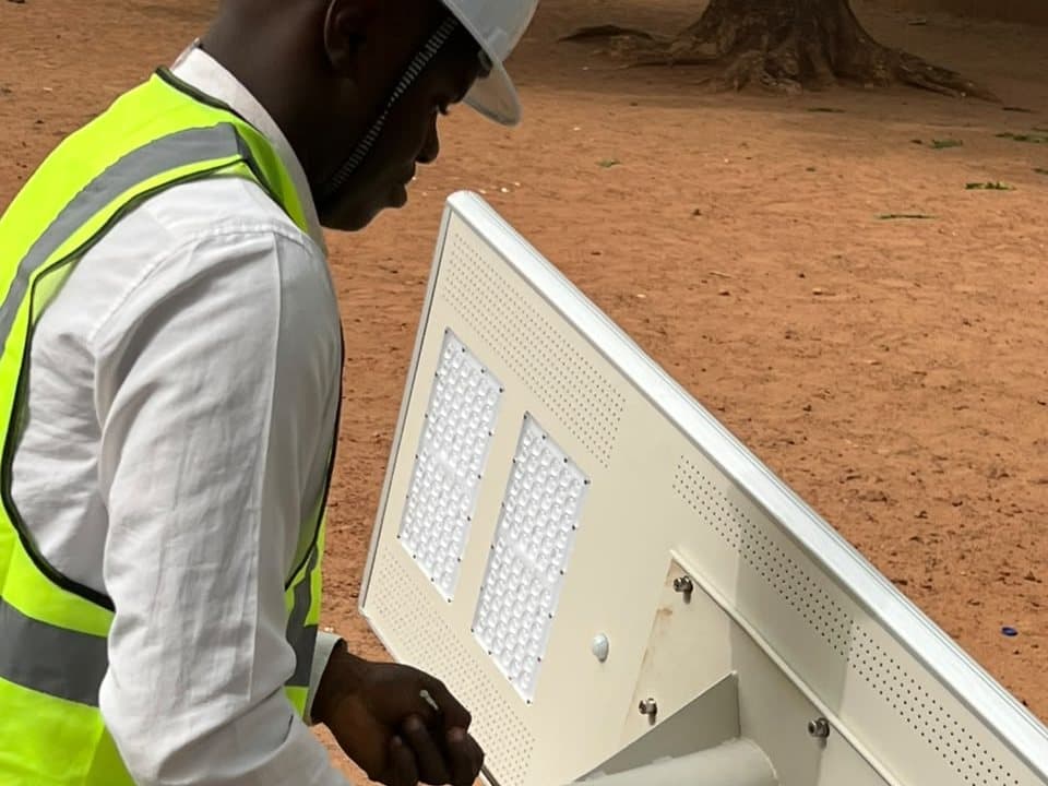 An engineer fitting the head of a solar street light before raising it