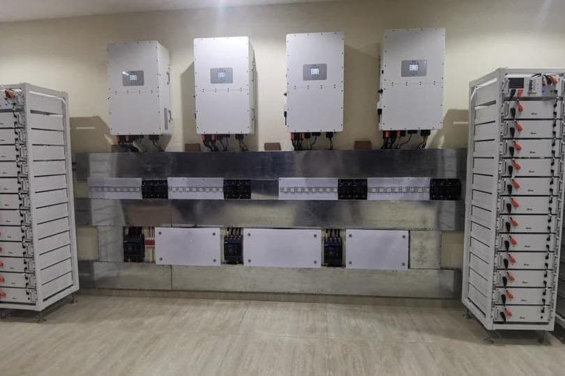 A commissioned bank of inverters wired into floor-to-ceiling lithium battery racks in a plant room